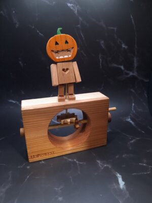 Wooden robot with a pumpkin head dancing on a wooden platform